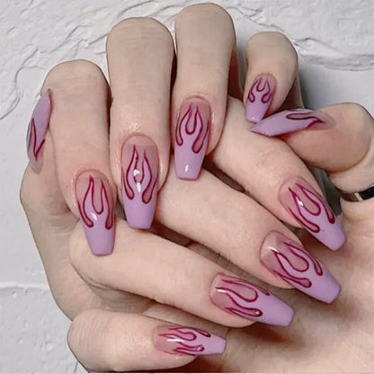 Wearing Nails design with flame patterns on soft purple false nails, showcasing a trendy nail art look.