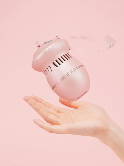 Multifunctional Electric Foot File Grinder Machine held in a hand with a pink background.