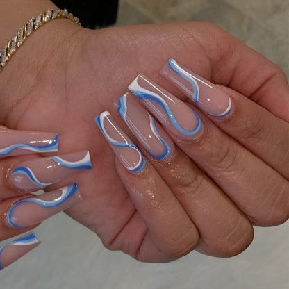 Wearing Nails finished soft nails with blue and white swirls on long false nails.