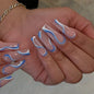 Wearing Nails finished soft nails with blue and white swirls on long false nails.
