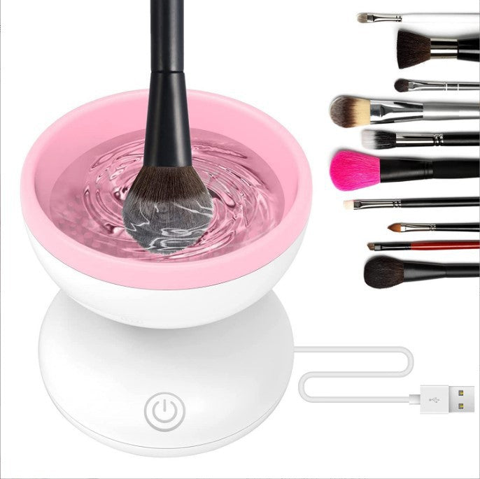 Electric Makeup Brush Cleaner Machine cleaning brush in pink bowl with water and various cosmetic brushes.